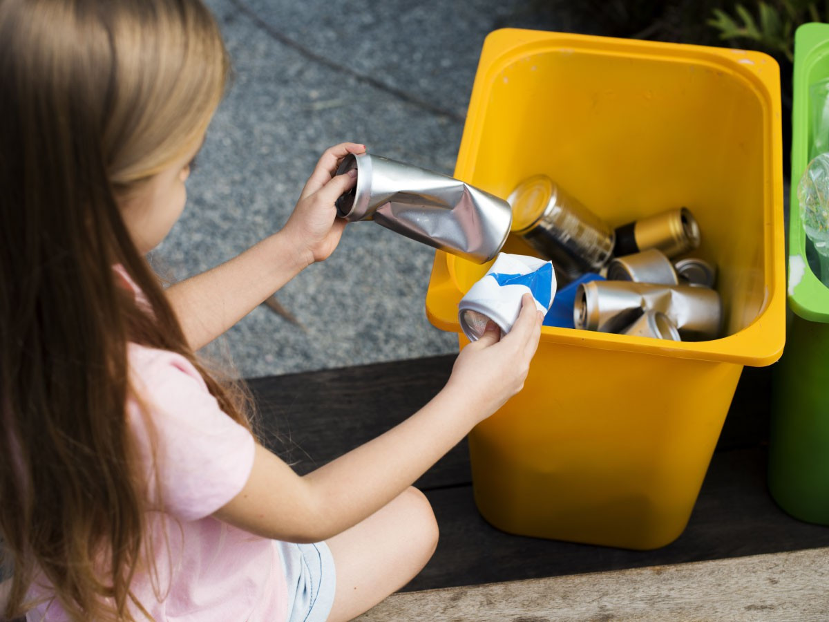Image of a little girl separating recycle can